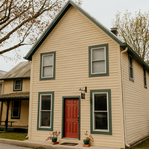 studio_500x500 Image of a historic home, with yellow Siding with a Red Door